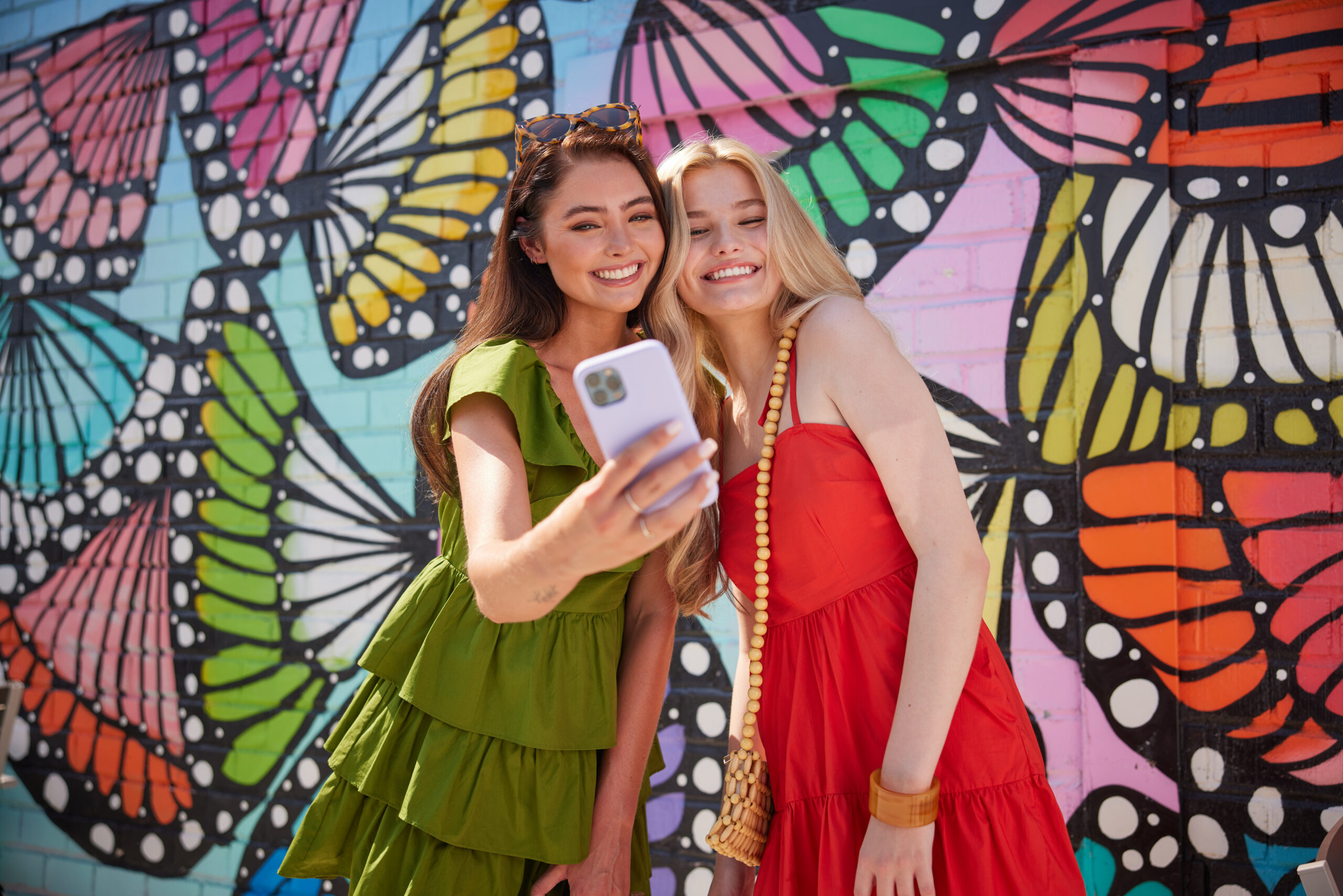 girls taking picture at butterfly mural