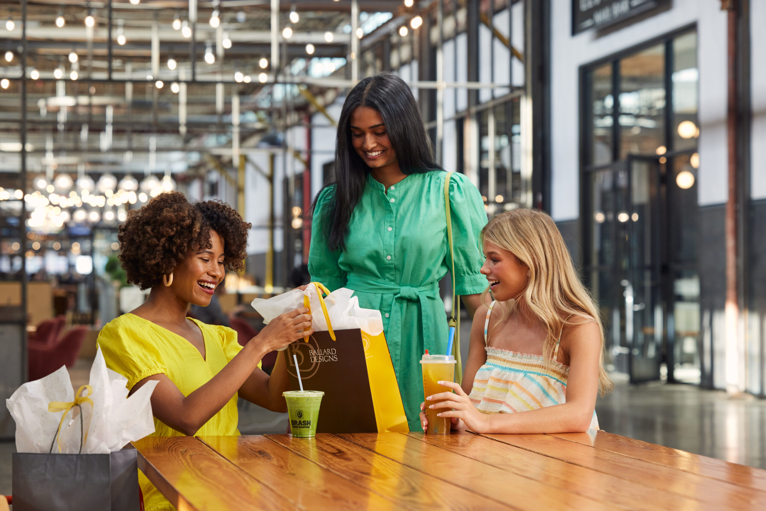 girls sitting at table with shopping bags