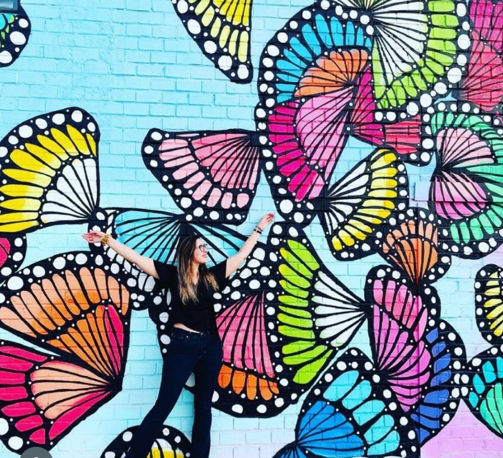 girl in front of butterfly mural