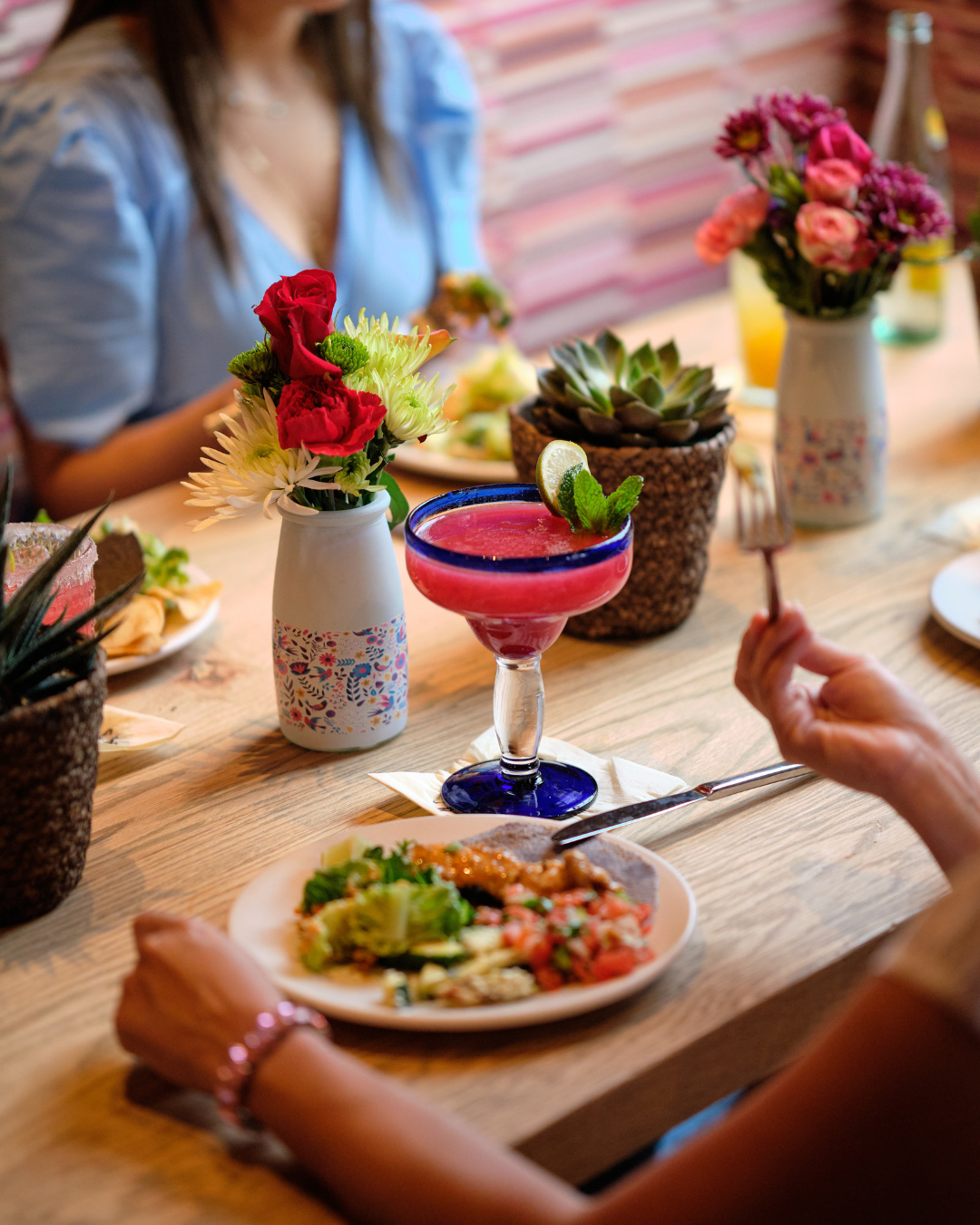 table with mexican food, margarita, flowers