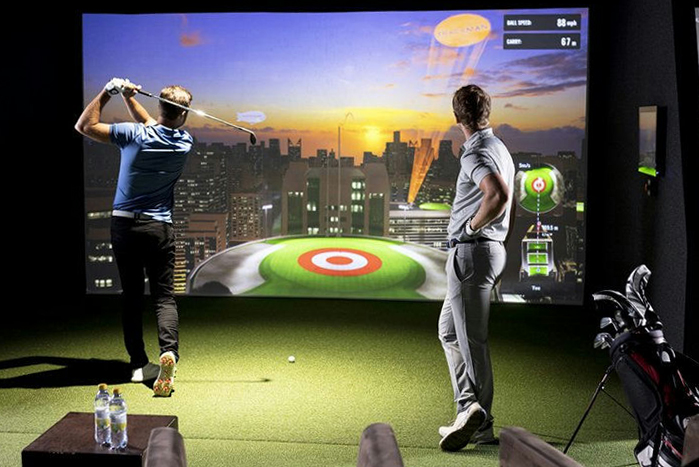 Two men using a golf simulator